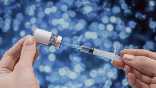 hand filling syringe with vaccine